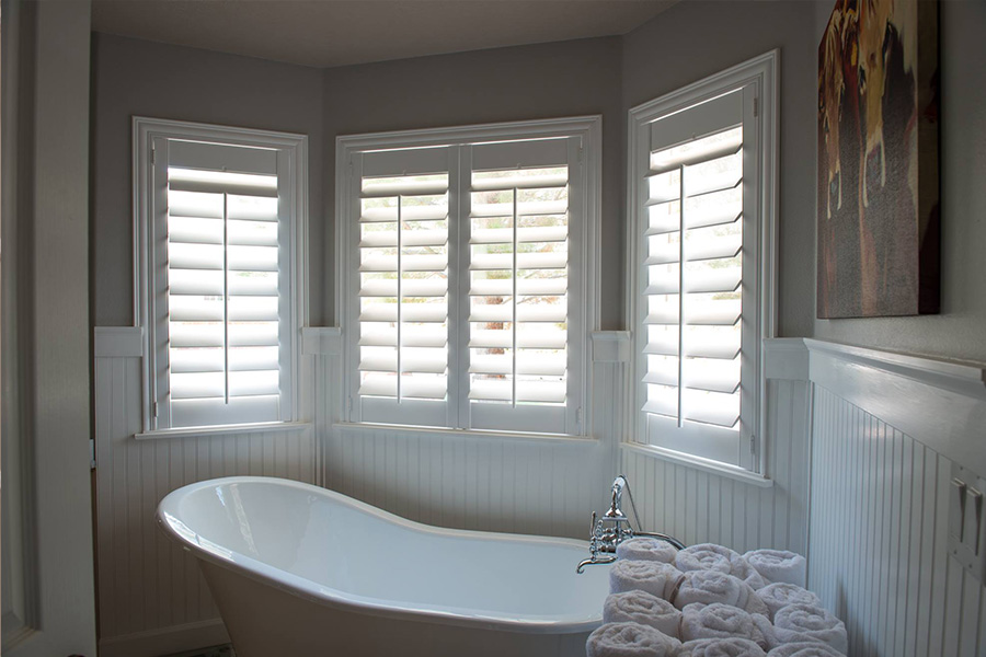 White Polywood shutters above a clawfoot white tub