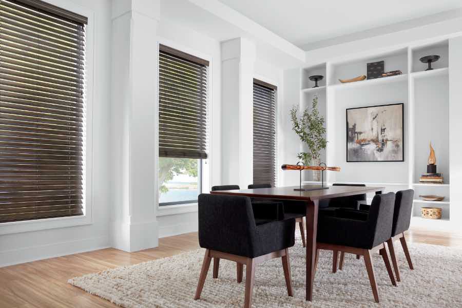 Installing blinds couldn't be easier than when you work with Sunburst Shutters! Brown faux wood blinds in a white dining room